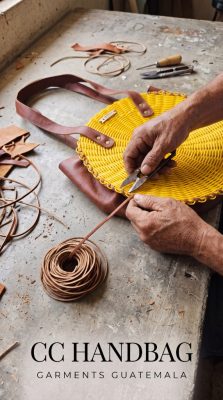 Master artisan in Guatemala handcrafting a yellow recycled plastic and leather-trimmed CC Handbag with custom brand plaque for B2B private-label fashion brands